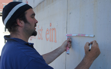 fassadenmaler gestaltet Schrift an fassade